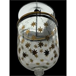 India Jane Interiors - pair of glass hanging lanterns, clear glass bell jars decorated with gold starburst patterns, each topped with a wide glass dish and suspended by three brass chains, the rim of each bell jar accentuated with a brass band, black metal hooks with a dragon head motif attach the chains to the rim