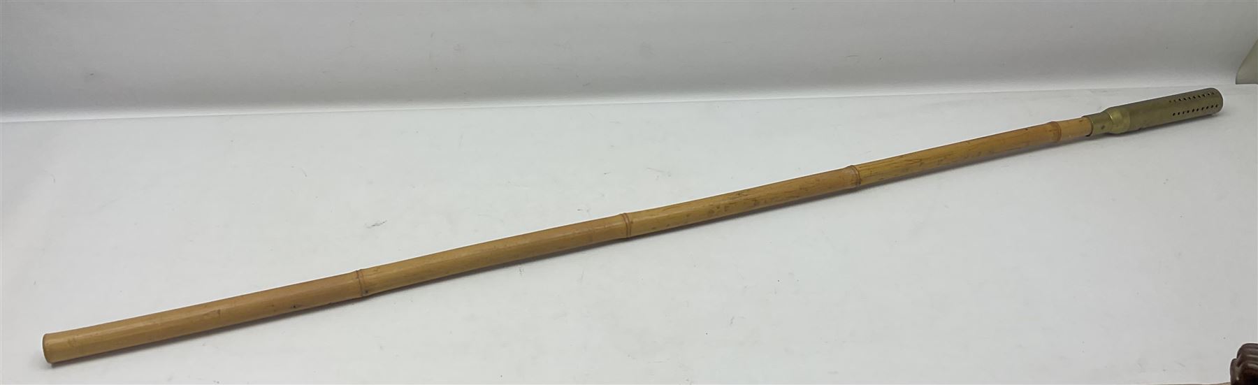 Bamboo cane torch, the pierced brass cover opening to reveal a wick, H144cm