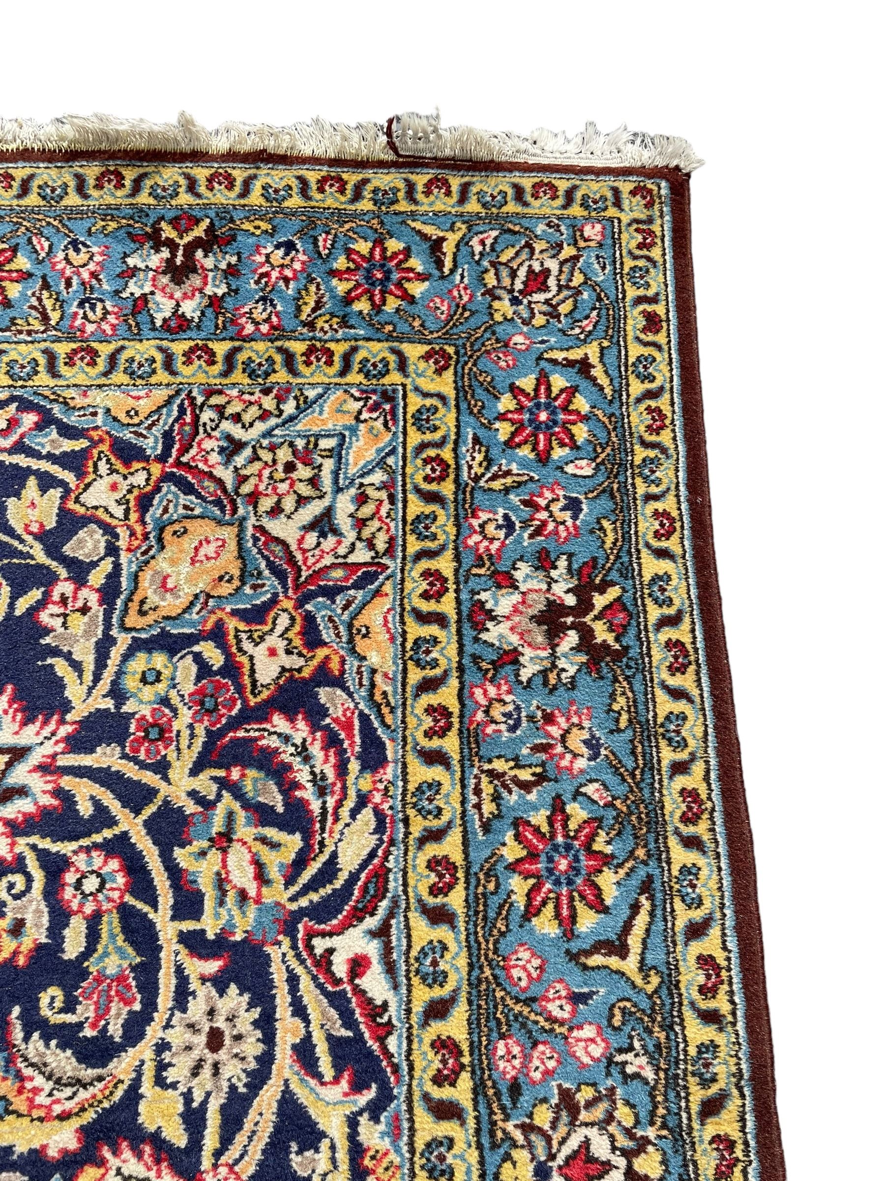 Persian indigo ground rug, overall arabesque design, central multi-point medallion surrounded by scrolling leafy branches and palmettes, the border decorated with repeating stylised plant motifs within guard stripes 