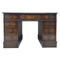 20th century mahogany twin pedestal desk, moulded rectangular top with red leather inset with gilt tooled border, central drawer over kneehole flanked by two banks of four graduating cockbeaded drawers, on plinth base