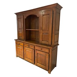 Large 20th century oak dresser, projecting cornice over open arched central section with two shelves, flanked by two panelled cupboards with two shelves, lower section with three drawers above three cupboards, on stile supports 