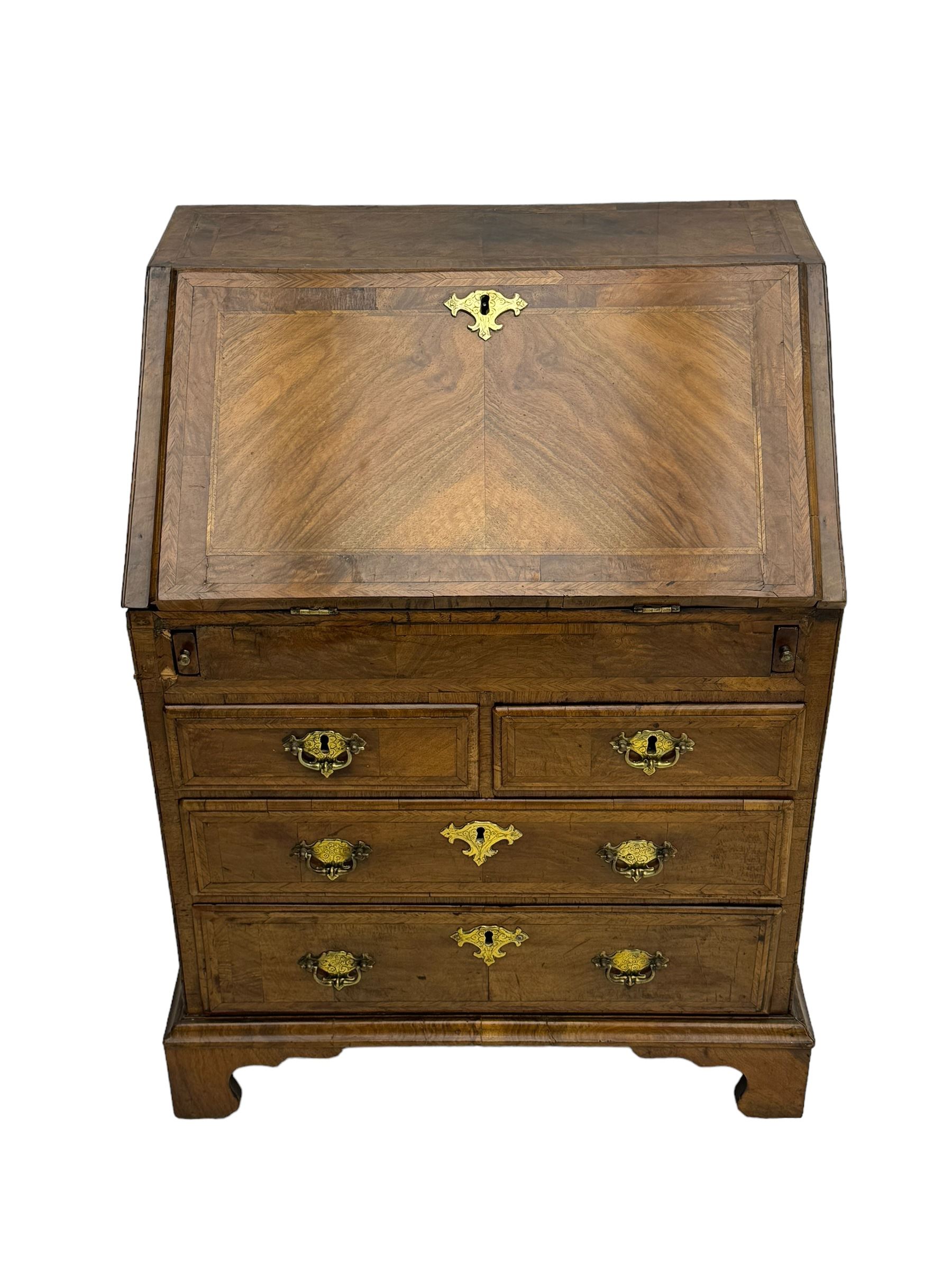 18th century walnut bureau, fall-front enclosing fitted interior with drawers and pigeonholes, over two short and two long drawers with brass escutcheon plates and handles, raised on bracket feet