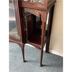 Art Nouveau period inlaid mahogany display cabinet, raised shaped and moulded pediment over projecting moulded cornices, the upper frieze inlaid with trailing branches and tulips, single astragal and bevel glazed door enclosed velvet lined interior fitted with shelves, flanked by curved glass panes decorated with pierced metal foliate spandrels, lower flanking shelves with mirror backs enclosed within shaped and pierced rails inlaid with flower heads, on tapering octagonal supports terminating to compressed pad feet, the lock stamped 'Salmon Bros, London' 