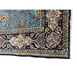 Persian Nain blue ground rug, overall arabesque design, the busy field decorated with interlacing branches and palmettes, indigo ground border with panels decorated with knots and lotus flower motifs, surrounded by trailing branches and flower heads, within guard stripes