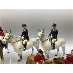 Beswick Hunting Group, comprising: two huntswoman on grey horses, model no 1730, huntsman on a bay horse, model no 1501, a seated fox, model no 1748, eighteen fox hounds and a spaniel, model no 967, all with printed marks beneath, together with three other ceramic huntsman on horseback and two hounds. 