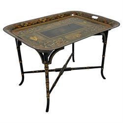 19th century tole ware tray of rectangular form, decorated with Japanese inspired floral motifs and gilt shells, with pierced handles, the associated ebonised and gilt stand, raised on ring turned splayed supports united by X-stretcher, decorated with gilt foliage