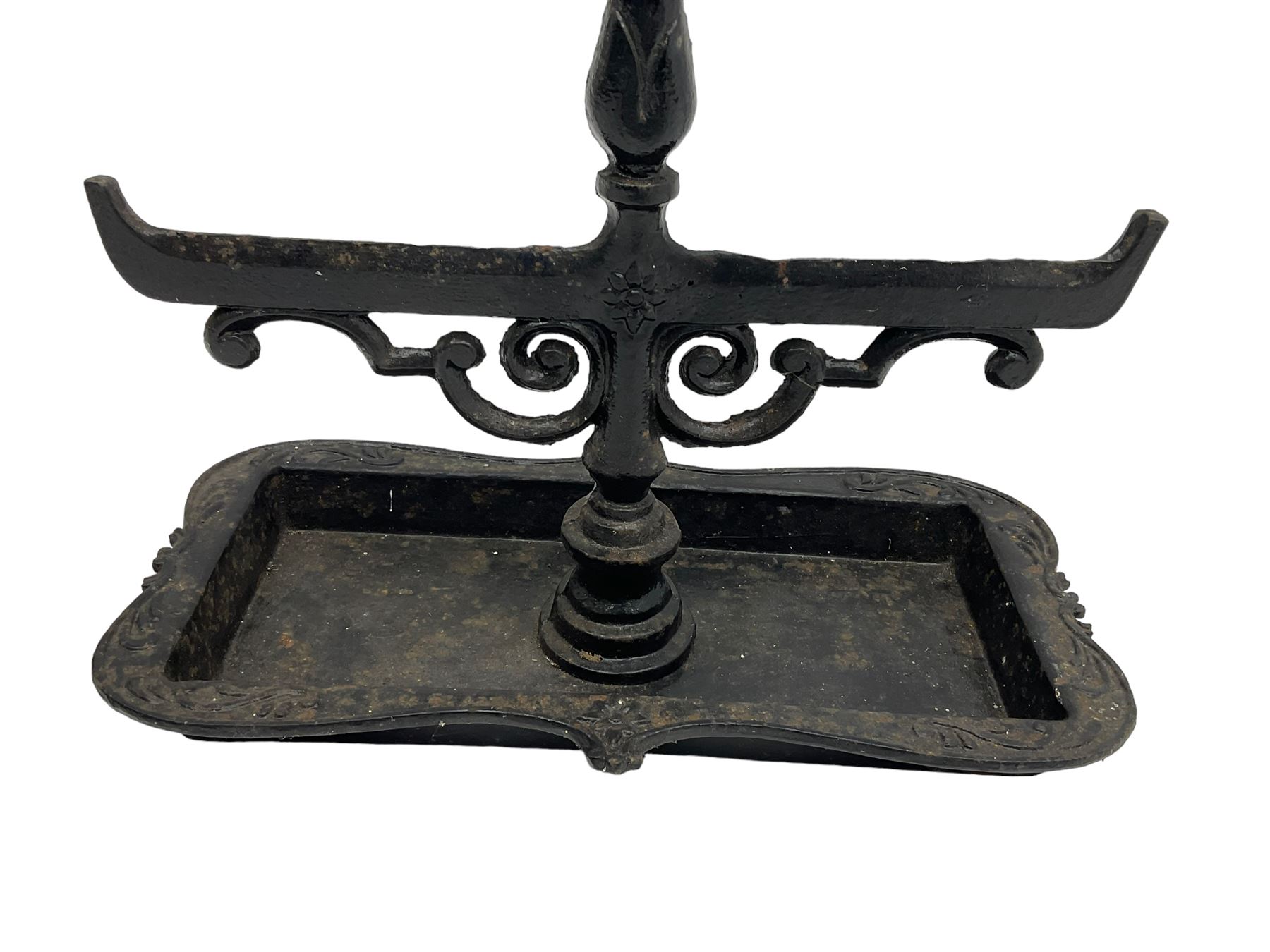 Black painted cast iron boot scraper with handle, decorated with scroll work with shaped tray 