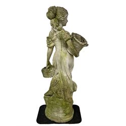 Weathered and painted cast stone garden statue, in the form of an Italian maiden carrying baskets with gathered flora and berries, on a shaped ovoid base