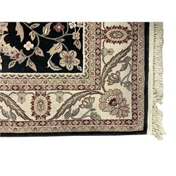 Persian design dark indigo ground rug, the field decorated with trailing branches and foliate motifs, repeating scrolling border with stylised plant motifs