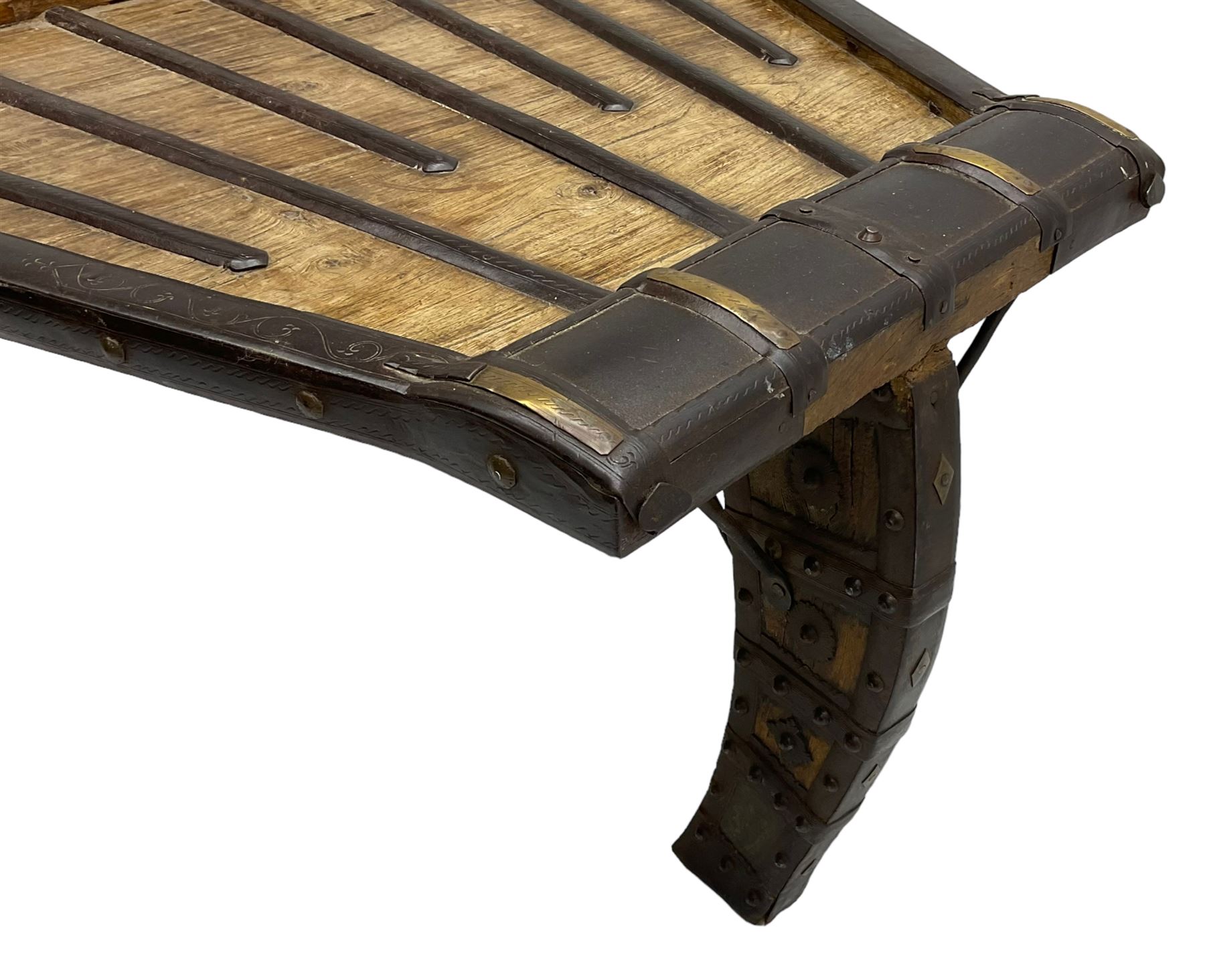 19th century Indian bullock / ox cart converted coffee table, trapezoidal top with applied metal decoration and iron stretchers, raised on three swept supports with stud decoration