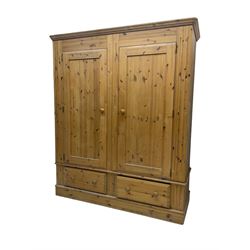 Pine double wardrobe, enclosed by panelled doors, two drawers to base