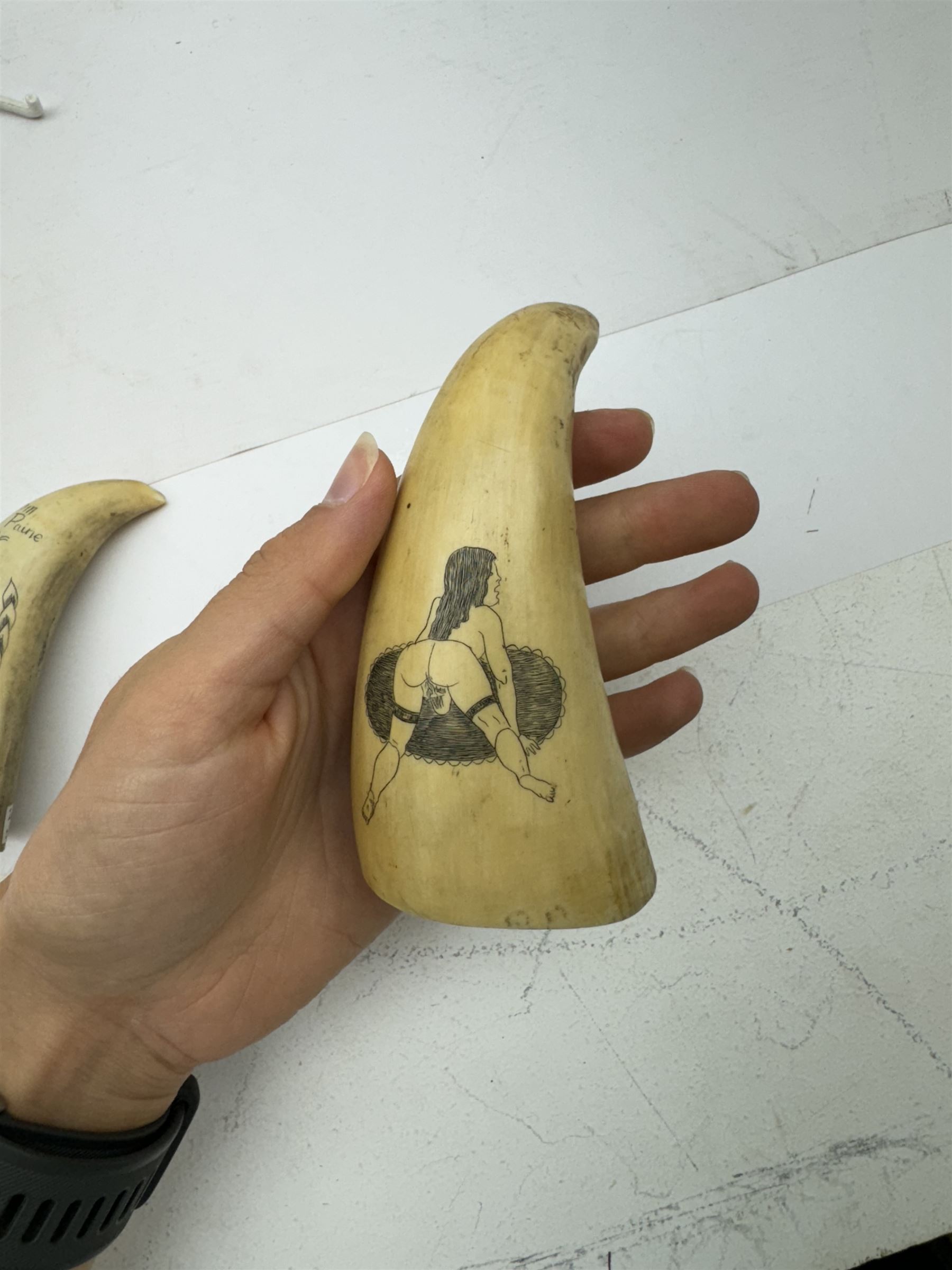 Two 19th century scrimshaw whale tooth, the first depicting a erotic scene, the second depicting Tom Paine, largest L11cm 