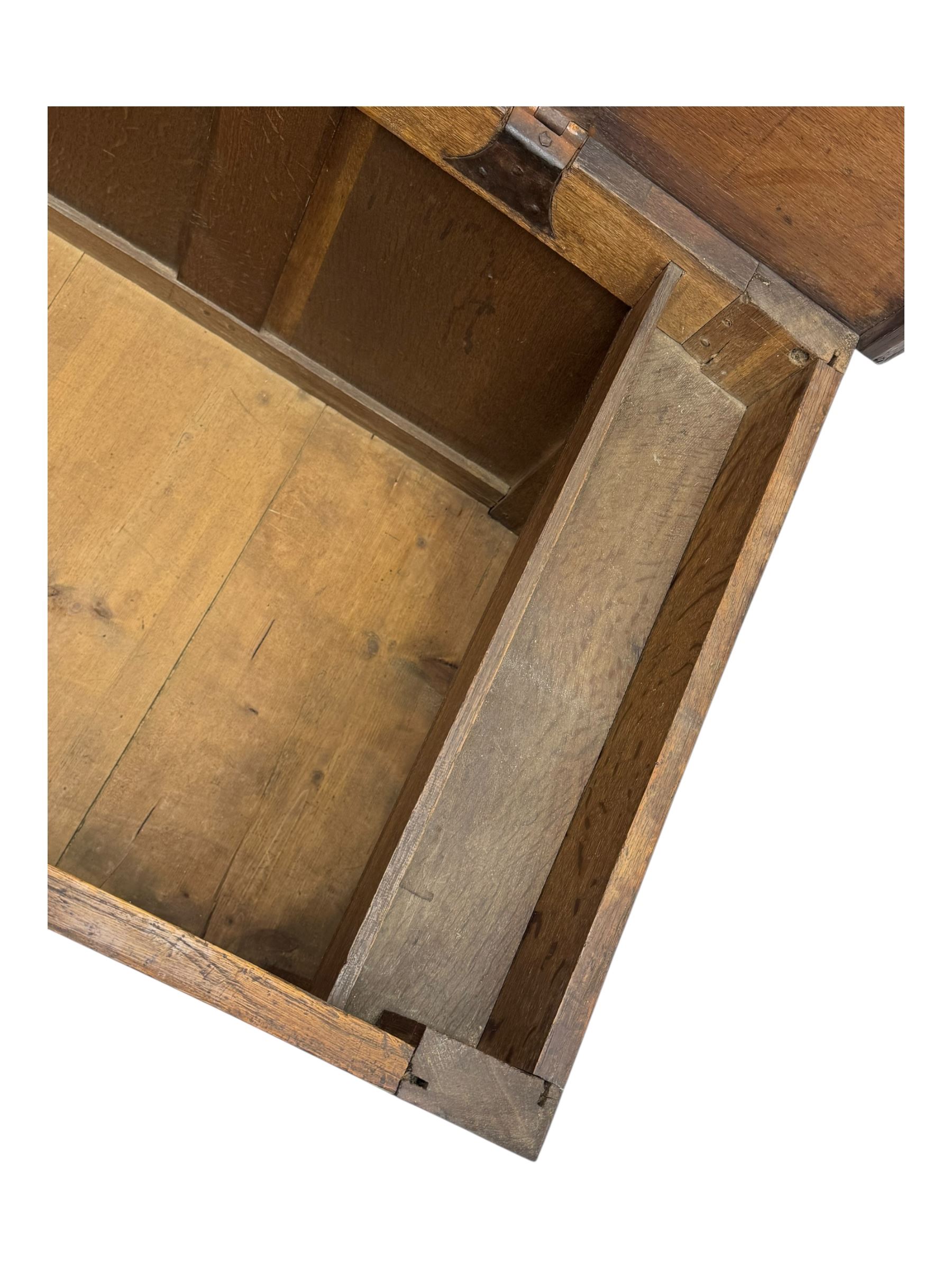 18th century oak blanket box, rectangular form with a hinged lid, the front decorated with raised geometric panelled mouldings, fitted with a central lock plate, raised on bracket feet