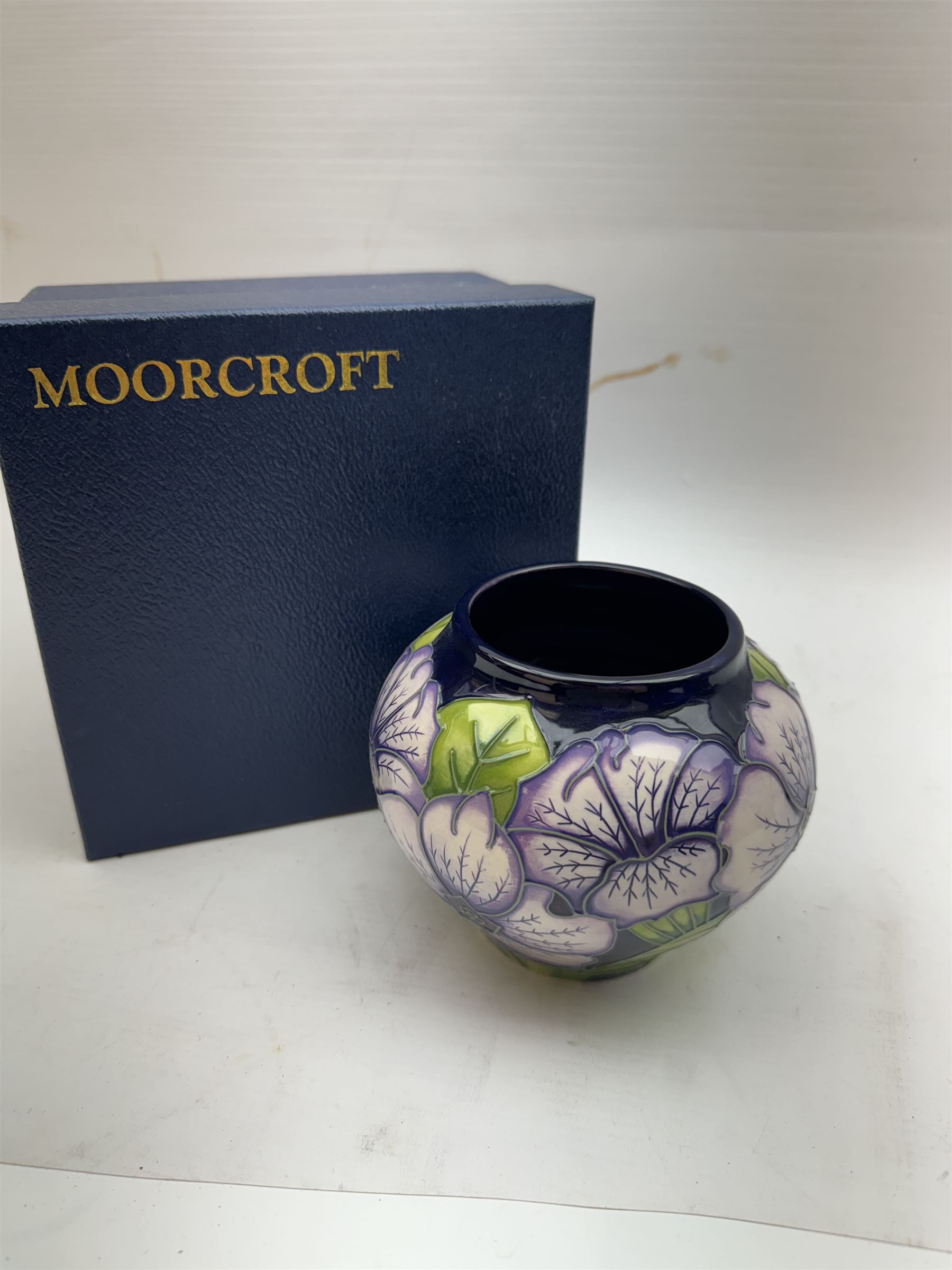 Moorcroft vase in Petunia pattern upon a ble ground, of squat baluster form, marked made for collectables to the base,  with original box, H12cm