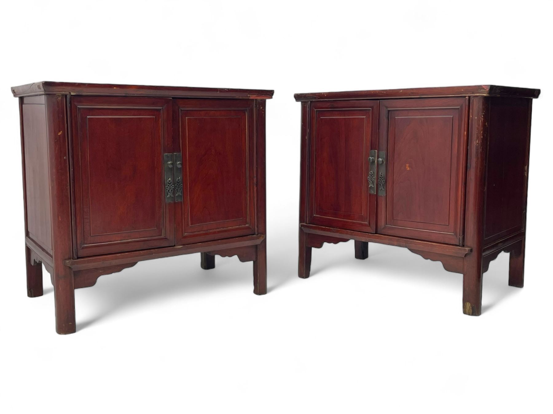 Pair of early 20th century Chinese red lacquered elm storage cupboards, rectangular top over two panelled doors, fitted with two internal drawers, on square supports with curved outer edge, panelled sides