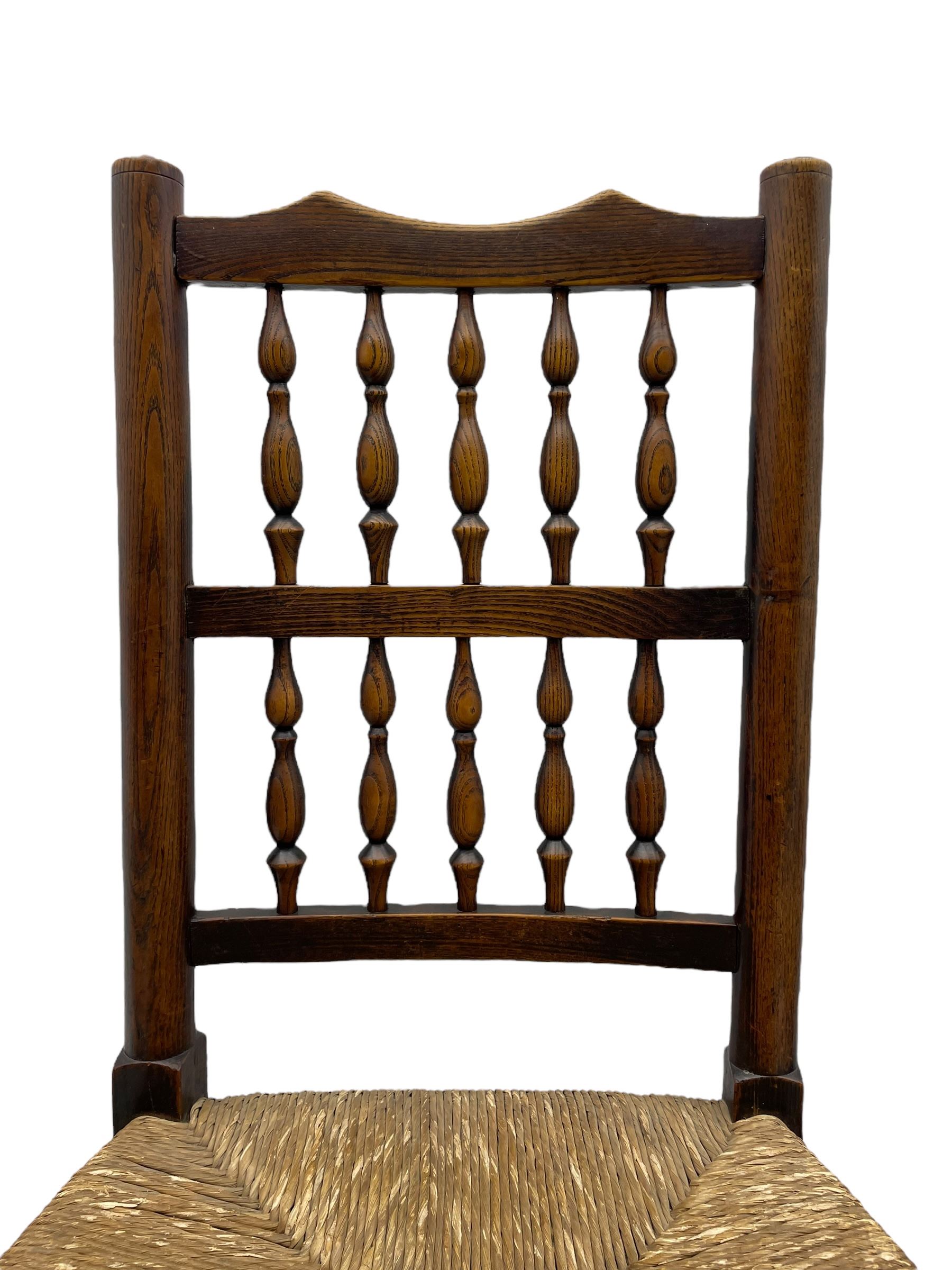 Matched set of twelve 19th century elm Lancashire spindleback dining chairs, shaped cresting rail over spindle back, rush seat, on turned supports united by turned stretchers, ring and globular turned front stretcher 