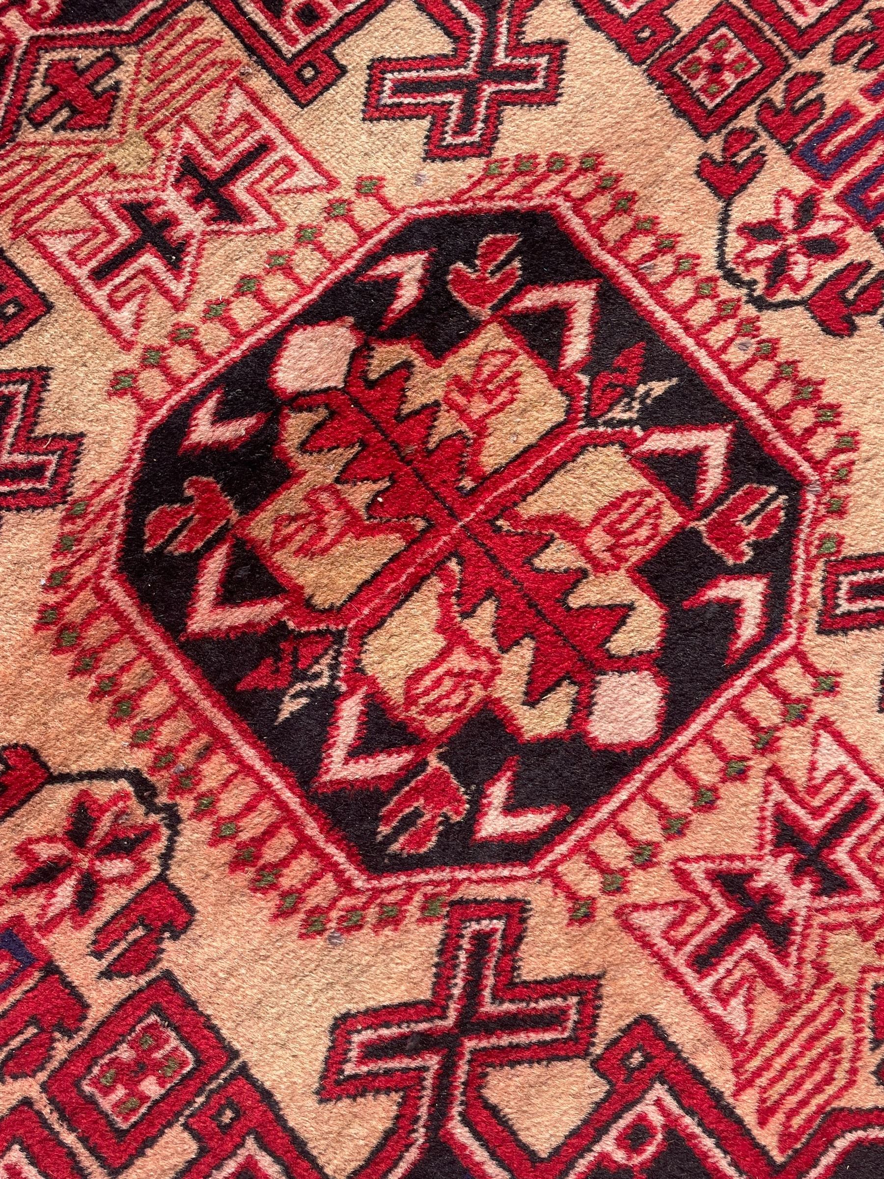 Persian Hamadan indigo and crimson ground rug, the field filled with three shaped medallions, overall geometric design, decorated with sandikli and hac motifs, geometric main border with repeating hooked motifs, within guard stripes decorated with small flower heads, outer crenelated fence band 