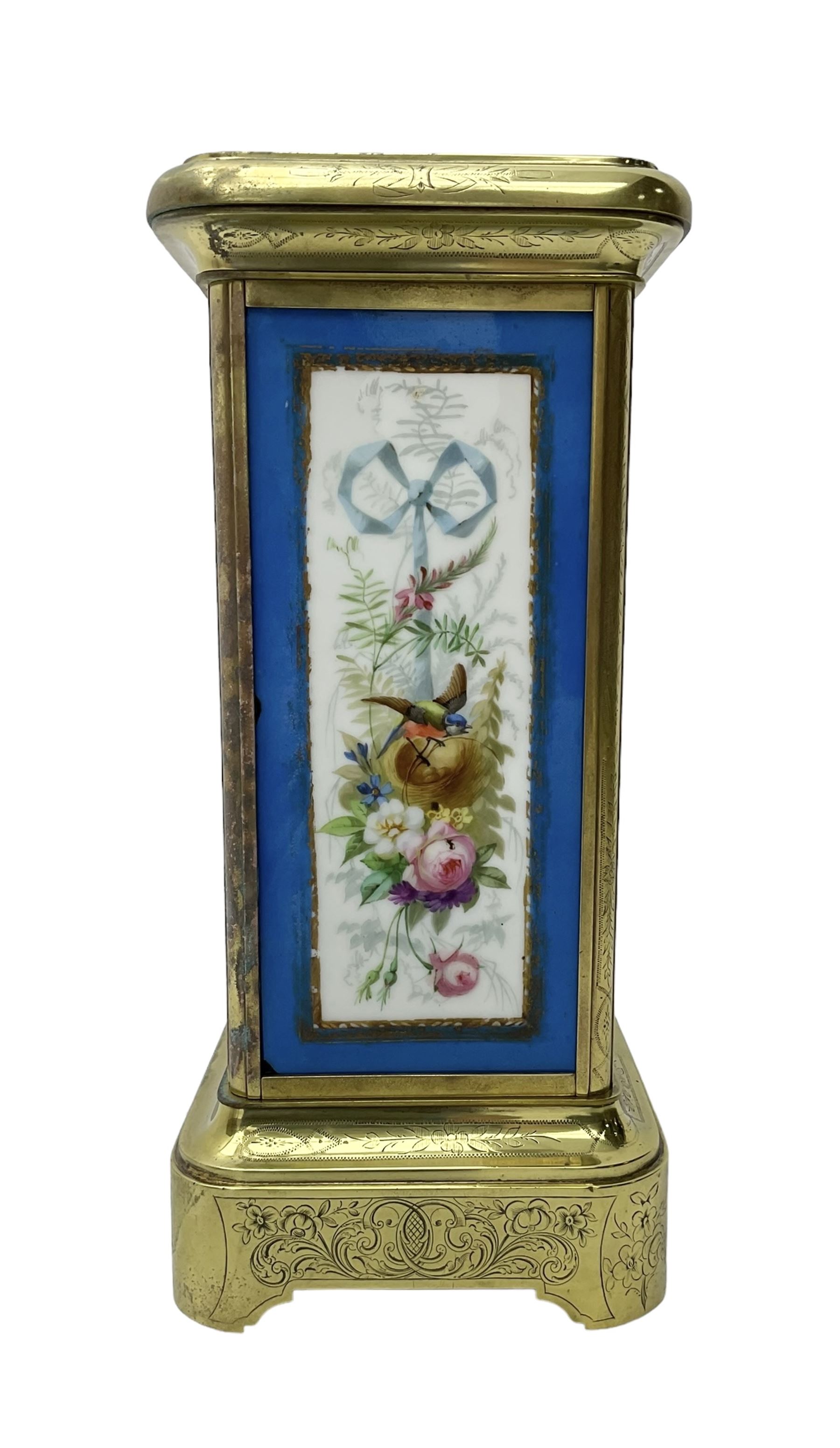 French - late 19th century 8-day mantle clock in an engraved brass corniche case with three rectangular porcelain panels decorated in the romantic Sevres style, dial with brass hands, cartouche Roman numerals and a depiction of cupid to the dial centre, rack striking movement sounding the hours and half hours on a bell. With pendulum.