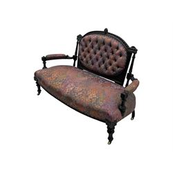 Late Victorian ebonised oak sofa, upholstered in muted purple fabric with iridescent floral pattern and nailhead trim, button-tufted backrest with carved crest rail and turned finials, scrolled padded arms supported by turned uprights, on turned supports with ceramic castors