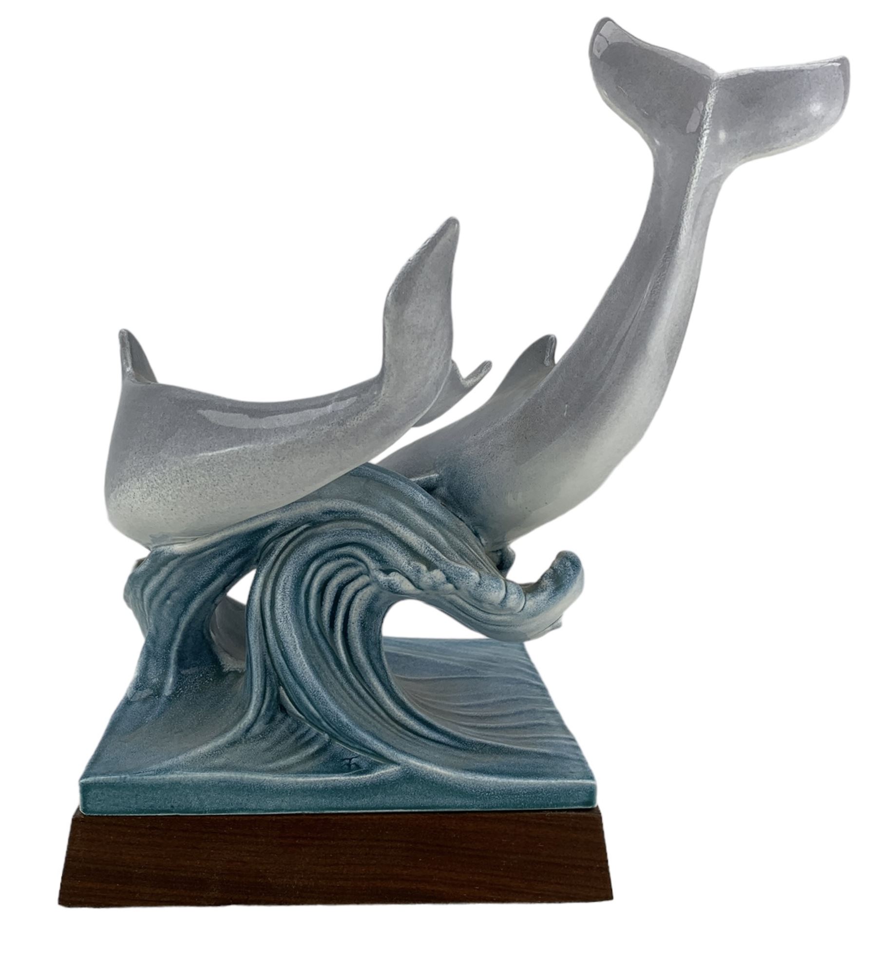 Tony Morris for Poole Pottery, leaping dolphin group, modelled over waves and mounted on a wooden base, H29cm. This model is a duplicate of a sculpture presented to Queen Elizabeth II and the Duke of Edinburgh on their visit to Poole Pottery in 1979, the original cast was destroyed after the production of the duplicate. Provenance: Arnold Smith, Chairman of Pool Potteries Collection