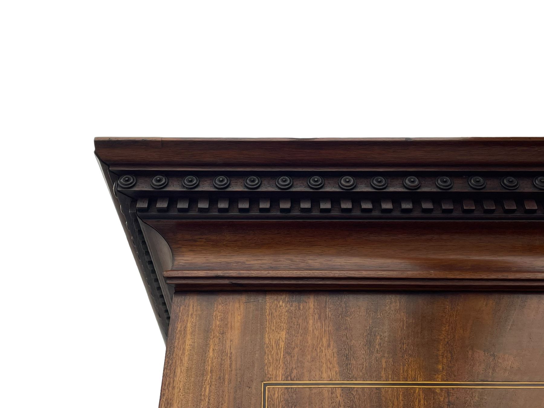 George III figured mahogany secretaire bookcase, projecting moulded dentil cornice decorated with single row of roundels, two figured mahogany doors with boxwood and ebony stringing enclosing three adjustable shelves and three drawers, moulded rectangular top over four long scratch-moulded drawers, the top secretaire drawer with fall front enclosing small drawers, pigeon holes and inset writing surface, shaped apron with bracket feet