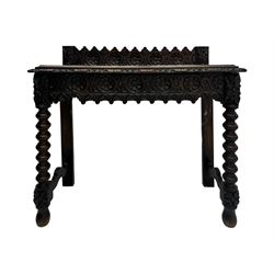 Victorian Gothic revival style carved oak console table, rectangular top with carved edge and raised back gallery, over deeply carved apron with floral and foliate motifs and central drawer, barley twist front supports and plain rear supports united by shaped stretchers, on front bun feet