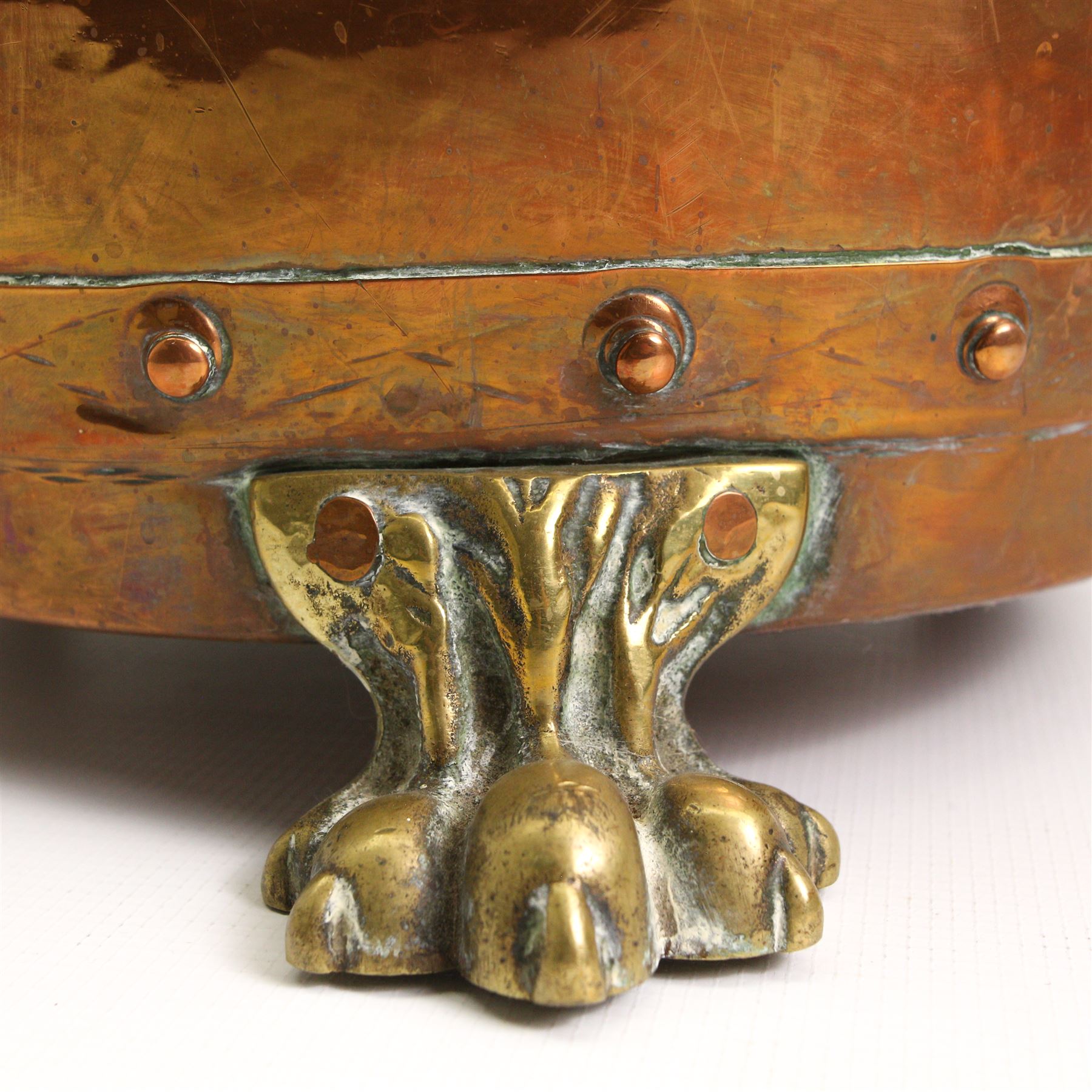 19th/ early 20th century copper coal bin, having twin cast brass handles, riveted base and three brass lion paw supports, H30cm, W42cm 