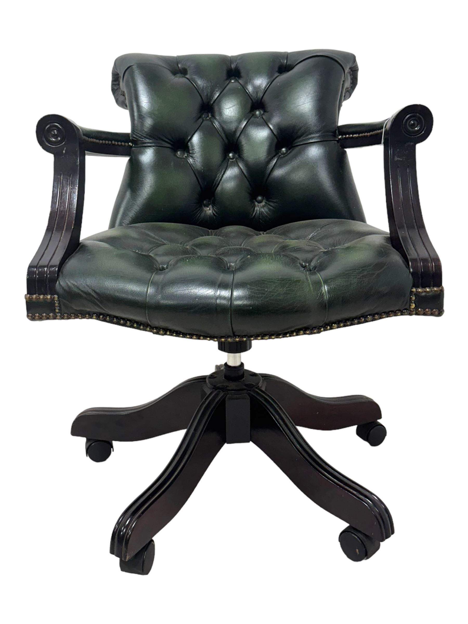 Victorian design Captains swivel desk chair, rolled tub shaped back with open arms, upholstered in deep buttoned green leather with studwork border