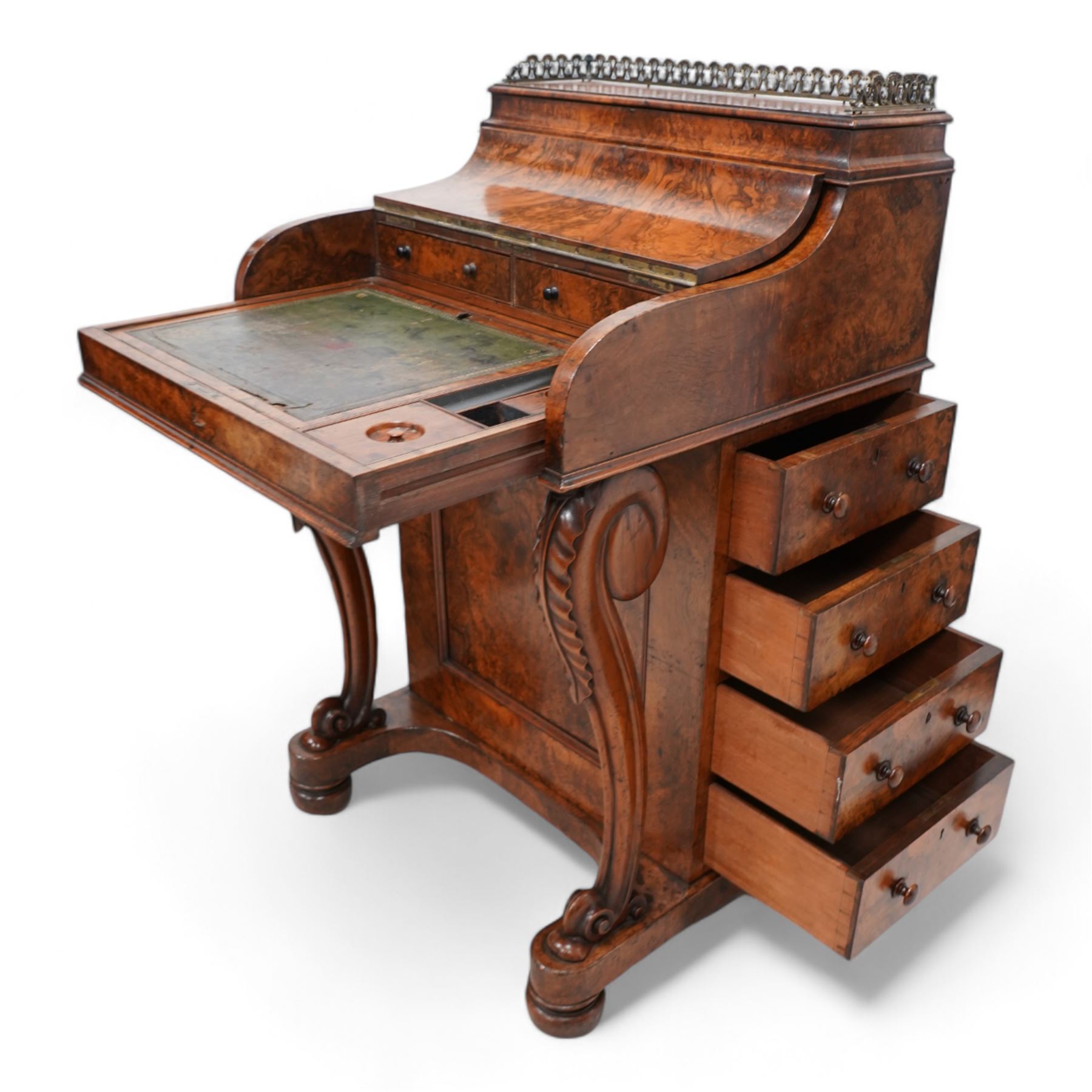 Victorian figured walnut piano top Davenport, the moulded top with brass gallery opens to reveal hidden compartment fitted with divisions, the piano lid enclosing slide with hinged leather writing surface, pen holder and two drawers, the right-hand side fitted with four drawers and the opposing side with four false drawers, on acanthus carved cabriole supports with scrolled terminals, sledge platform on turned feet 