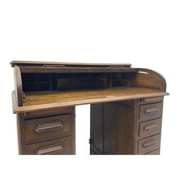 Early 20th century oak twin pedestal roll top desk, tambour roll enclosing fitted interior, each pedestal fitted with four drawers and slide, on plinth base 