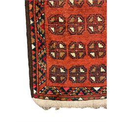 Small Persian red ground rug, the field decorated with four rows of Gul motifs