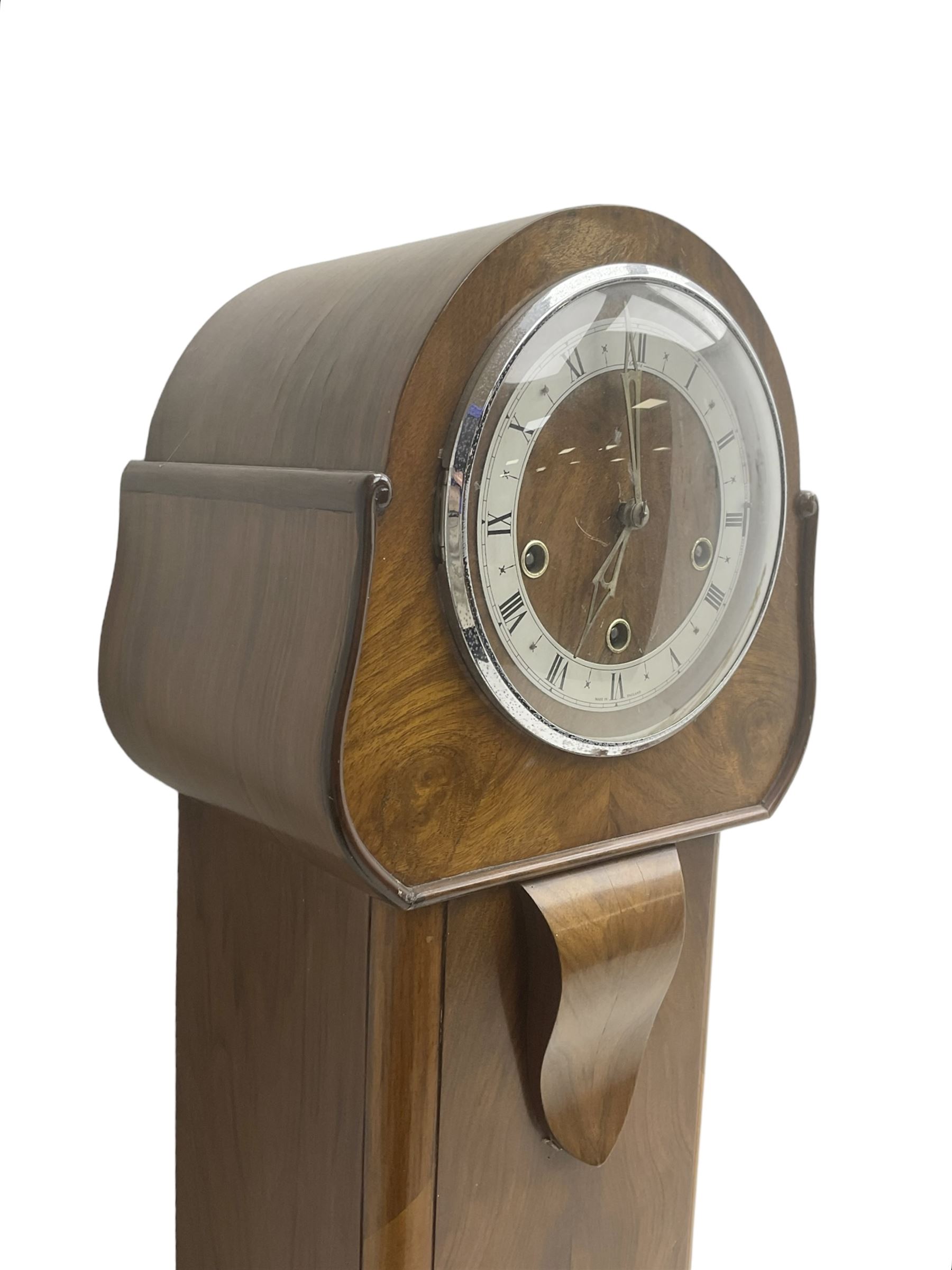 English - 1950's walnut 8-day quarter chiming grandmother clock, rounded top with a splayed base on bracket feet, wooden dial centre with a silvered chapter dial, chrome hands and roman numerals enclosed within a chrome bezel, three train going barrel movement chiming the quarters and hours on 8 gong rods. With pendulum.