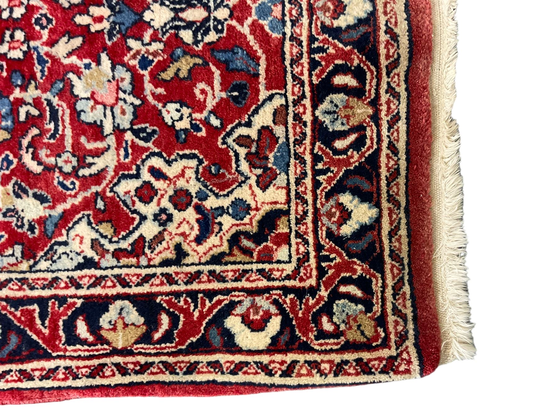 Persian crimson ground rug or mat, field decorated with central medallion and all-over scrolling floral motifs, border with repeating palmettes