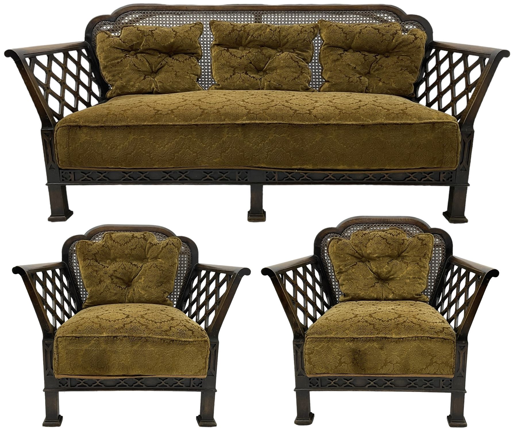 Early 20th century three-piece bergère suite - three seat sofa (W177cm, H82cm, D75cm); pair of matching armchairs (W84cm); single caned back with 'cock-pen' panelled arms, upholstered in foliate pattern fabric, blind fretwork lower frieze over square feet 