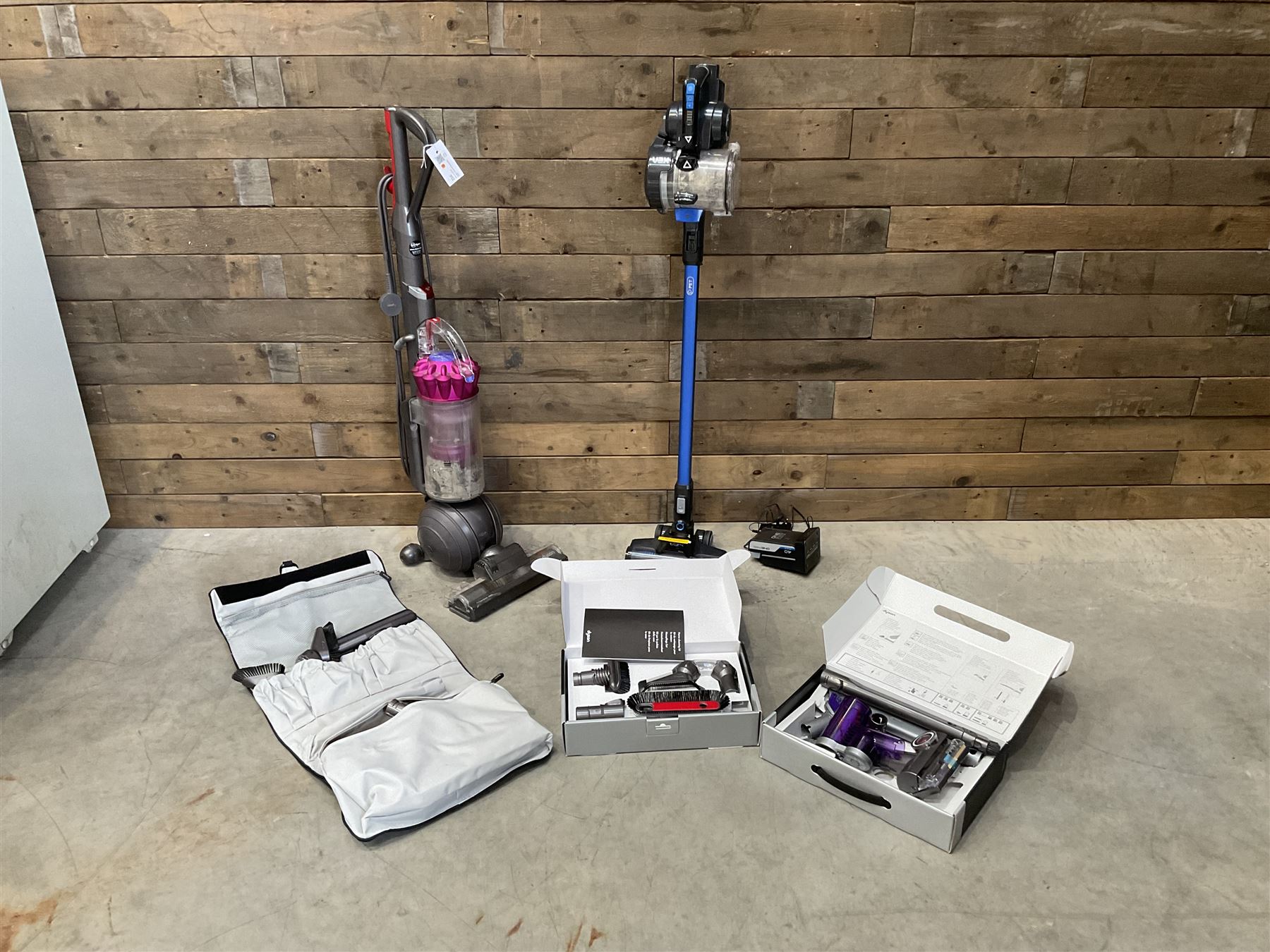 Dyson DC40 vacuum cleaner with various attachments, and a Vax cordless vacuum cleaner with single battery and charger