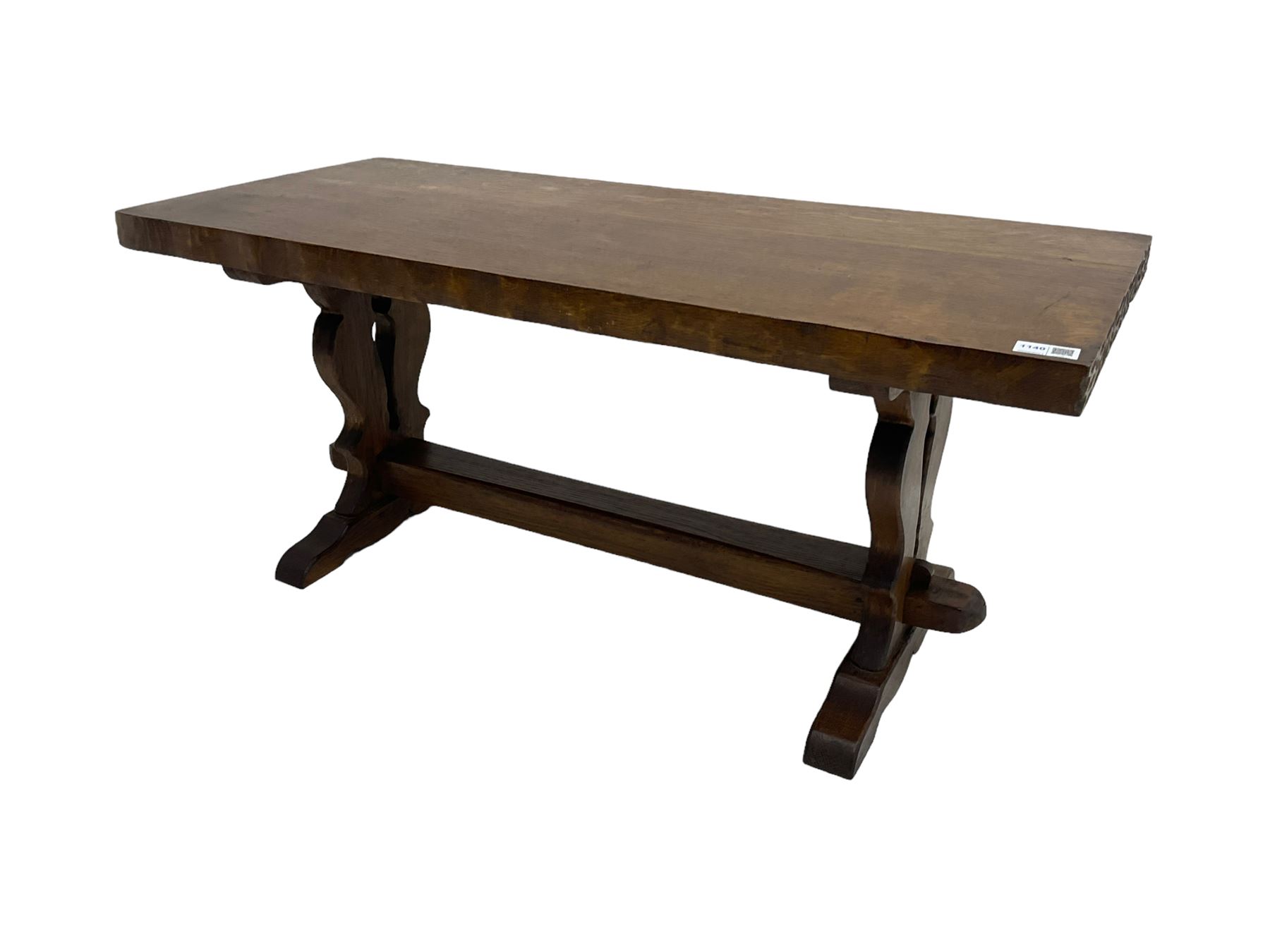 Solid oak coffee table, rectangular waved cut top with tooled ends, on shaped and pierced end supports joined by pegged stretcher 