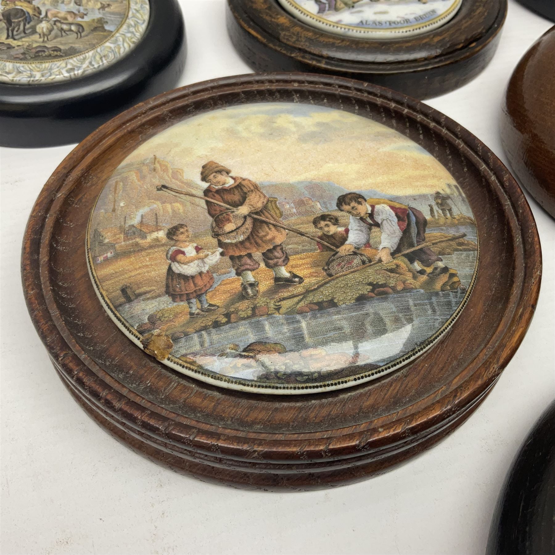 Six framed Prattware pot lids comprising 'Bear, Cock & Lion', 'Bear on Rock', 'Alas! Poor Bruin', ' Lady, Boy and Goats', 'The Shrimpers' and one other, largest D15.5cm (6)