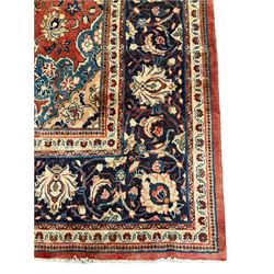 Persian Kashan crimson ground carpet, central shaped pale ground medallion surrounded by interlacing branches and stylised floral motifs, indigo main border with scrolling foliage design, within guard stripes 