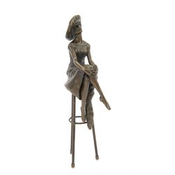 Bronze modelled as a female figure seated cross legged upon a chair, H28cm