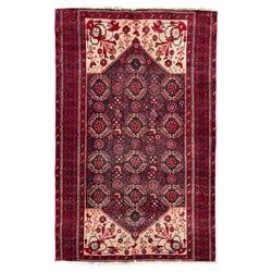 Persian Baluchi dark indigo and crimson ground rug, the field decorated with rows of repeating Pitrak motifs and surrounded by small bird and flower head motifs, floral urn decorated spandrels, repeating Pitrak border within guard stripes