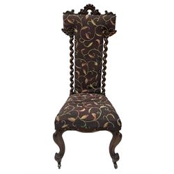 Victorian walnut prie-dieu chair, cresting rail carved with cartouche and extending scrolling foliage, back flanked by spiral turned column uprights, upholstered in foliate patterned fabric, raised on cabriole supports with scroll feet and castors