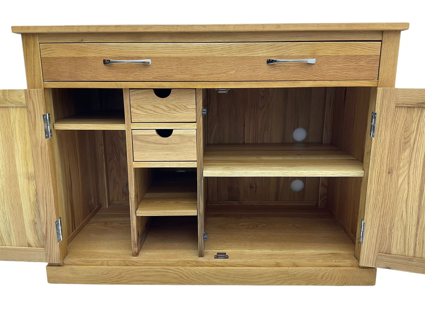 Contemporary light oak sideboard desk, rectangular top with full length drawer, hinged front panel revealing pull-out keyboard tray, over two panelled doors enclosing an assortment of shelves and compartments with cable management holes, on plinth base