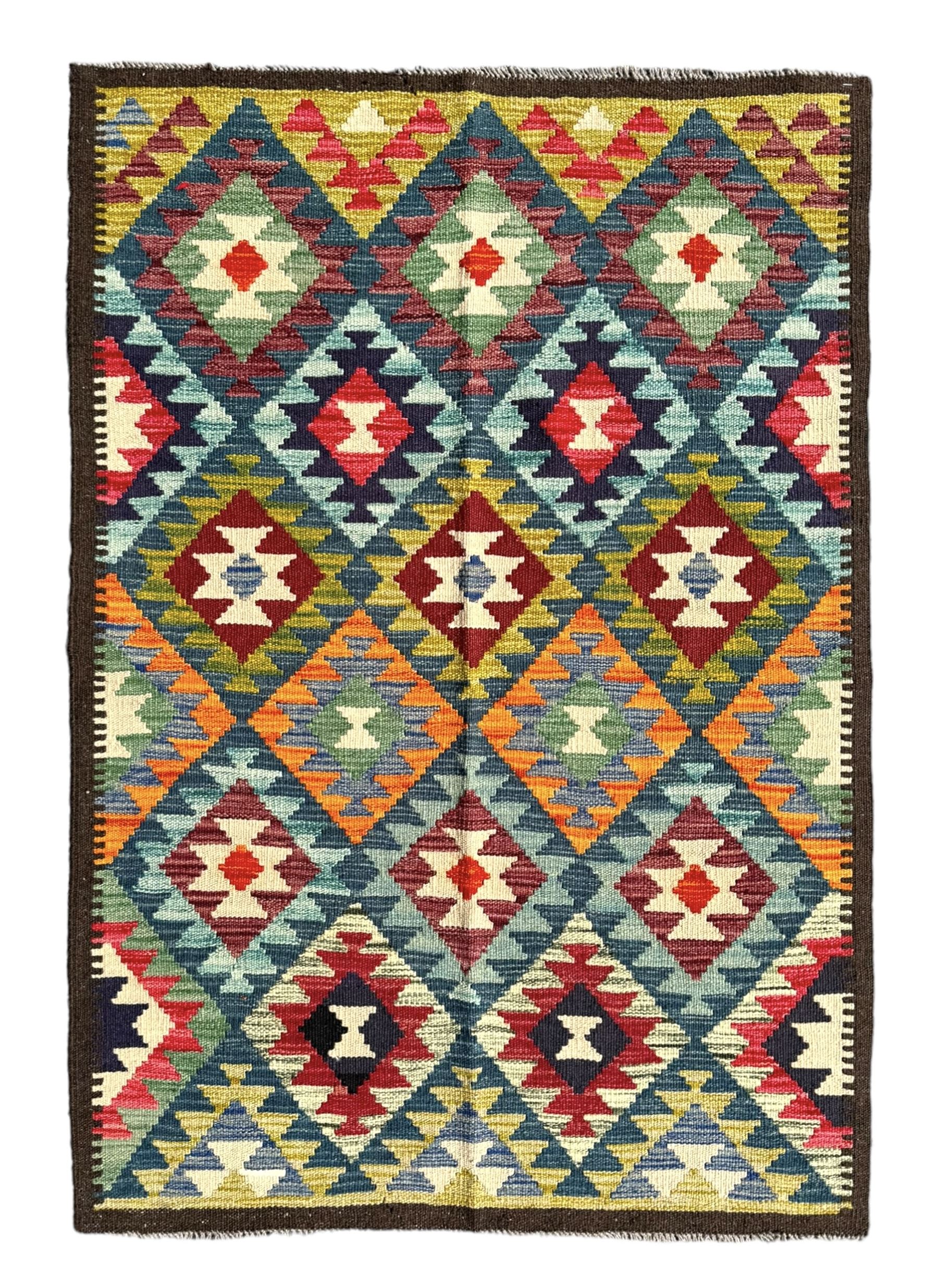 Maximana Kilim ground rug, the field decorated with a geometric pattern of multi-coloured diamonds and triangles, each containing stylised motifs, enclosed by a plain brown border