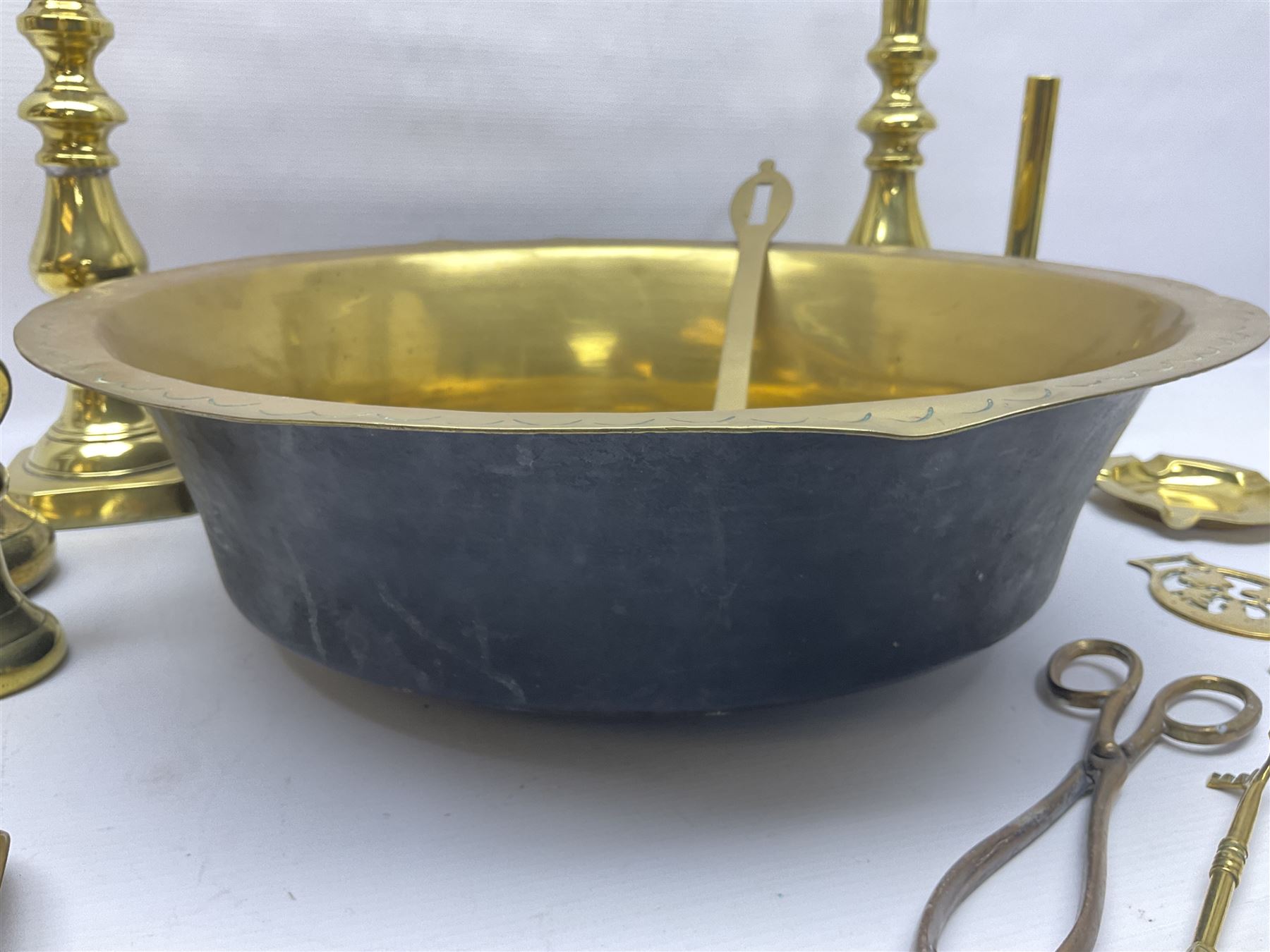 Collection of early 20th century and later brass, to include a large bowl with punched decoration to rim, pair of candlesticks, inkwell, weights, horse brasses, etc 