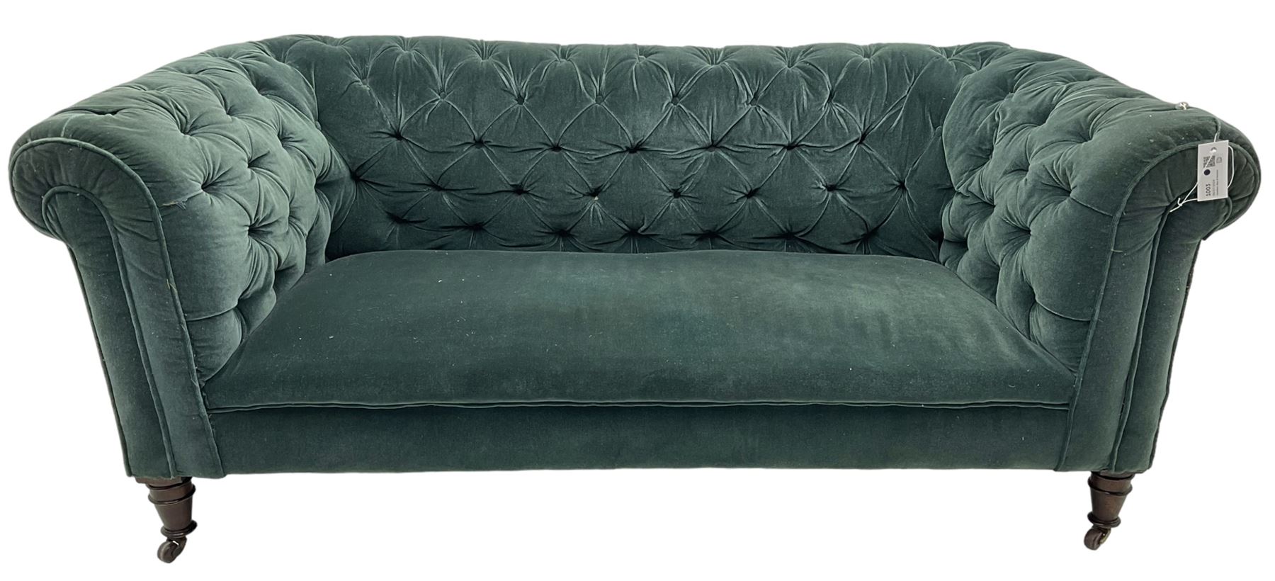 Victorian hardwood-framed Chesterfield sofa, traditional shape with low back and rolled arms, upholstered in teal buttoned fabric, on turned front feet with brass and ceramic castors 