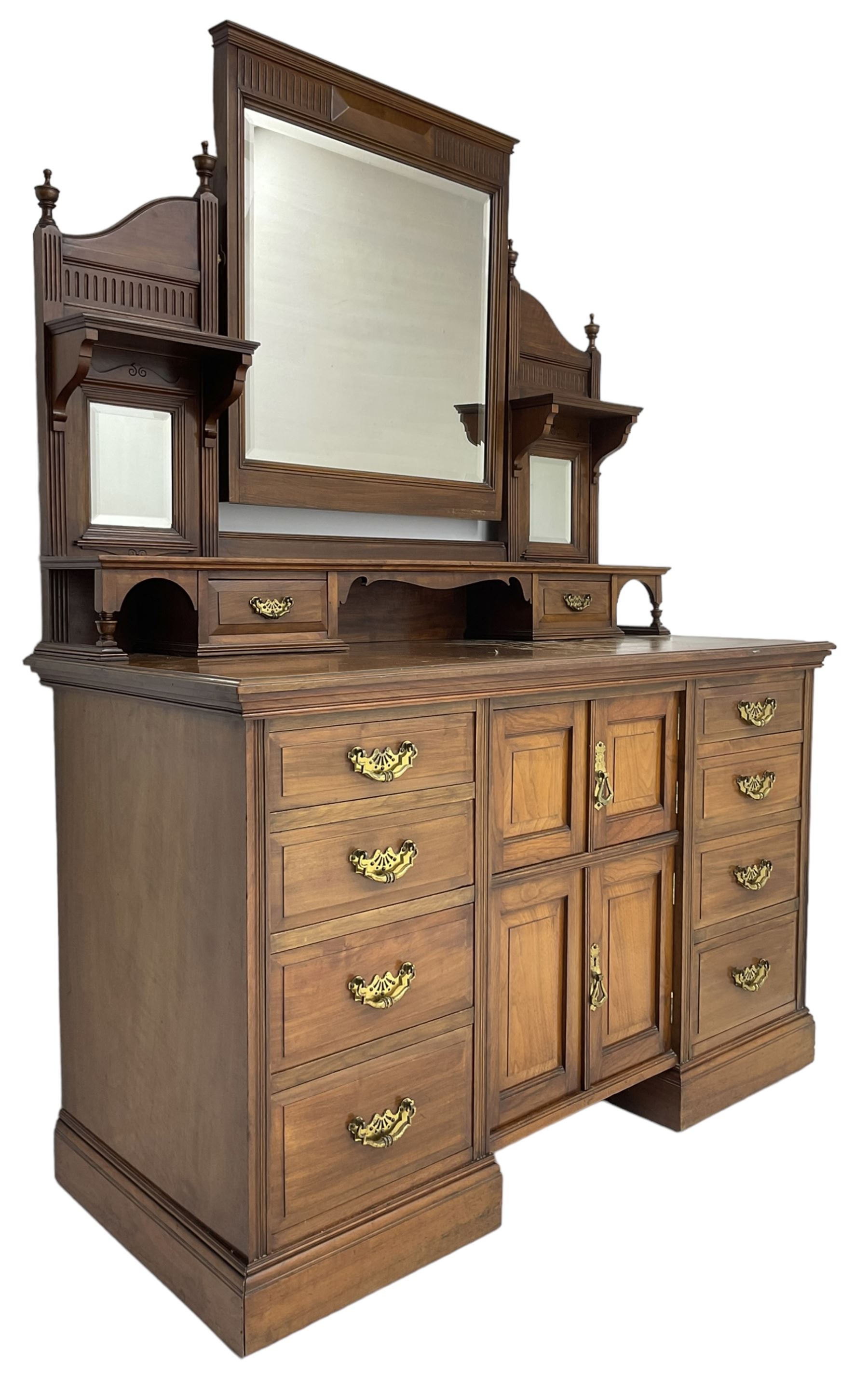 Edwardian mahogany dressing chest, raised triple mirror back with bevelled plates and fluted decoration over two trinket drawers, the base fitted with two central cupboards flanked by four graduating drawers to each side