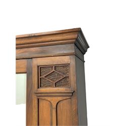 Edwardian walnut wardrobe, projecting moulded cornice over bevelled mirror glazed door, panelled uprights with upper glass panels behind fretwork, the base fitted with single drawer 