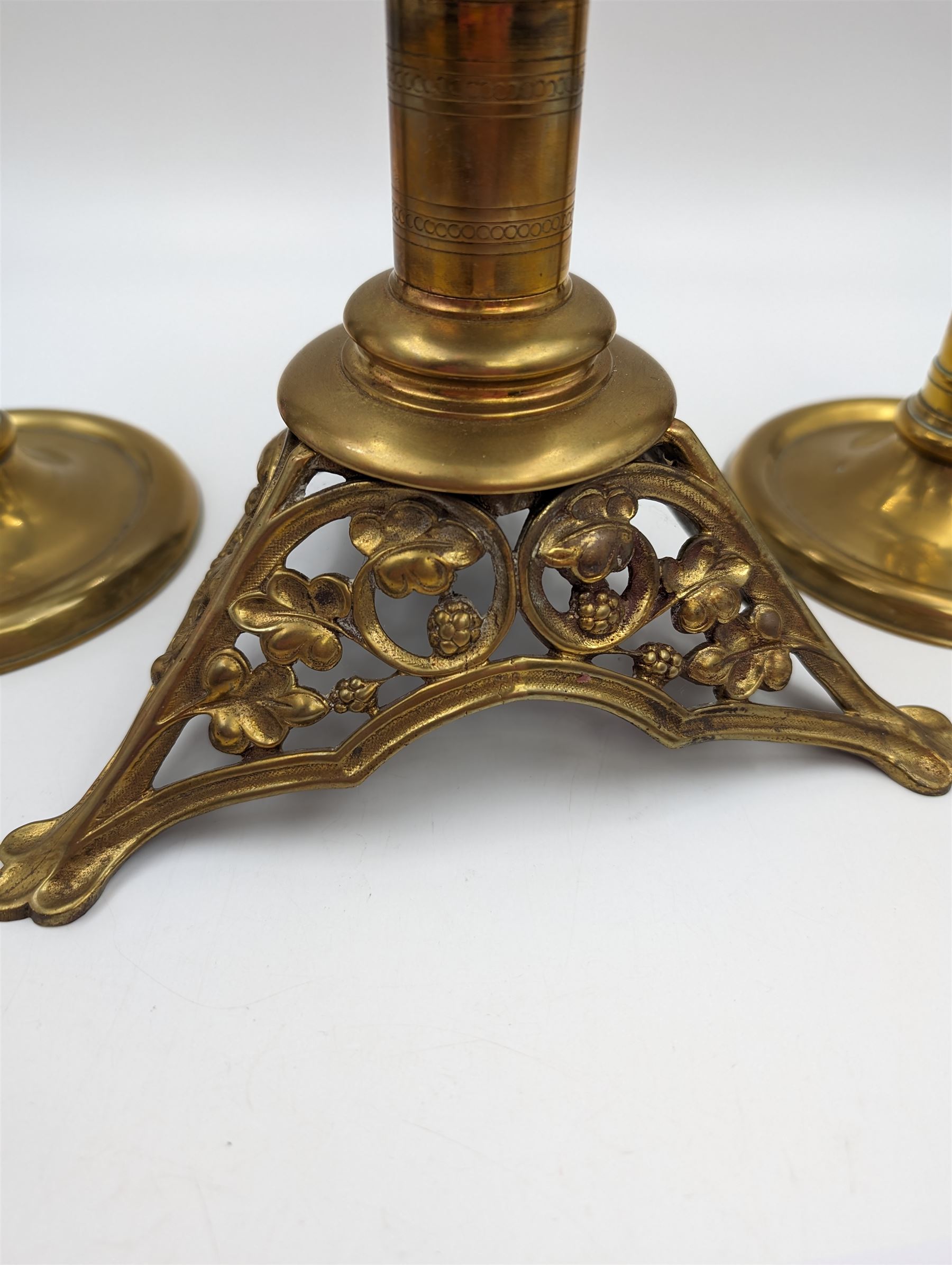 Brass candlestick with a knopt stems and triform base, together with two other brass candlestick 