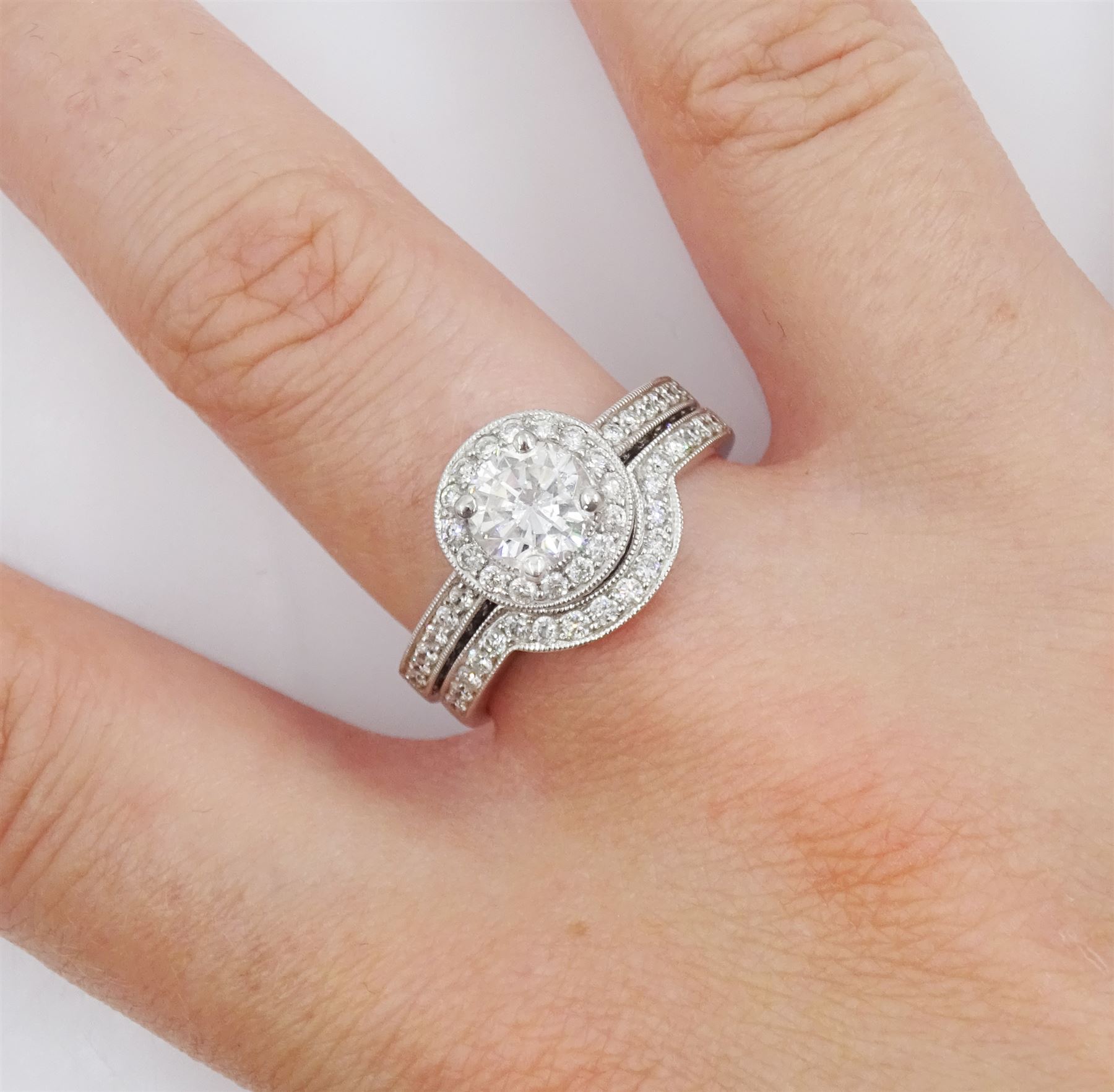 Platinum single stone round brilliant cut diamond ring, with pave set diamond surround, gallery and shoulders, principal diamond approx 0.90 carat, with platinum diamond set band, both hallmarked