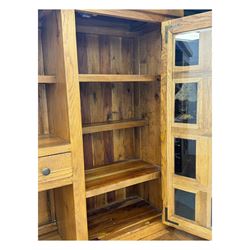 Oak dresser, upper section with twin glazed cupboard doors and central shelving with two trinket drawers, lower section fitted with six drawers over three panelled cupboard doors, raised on shaped feet 